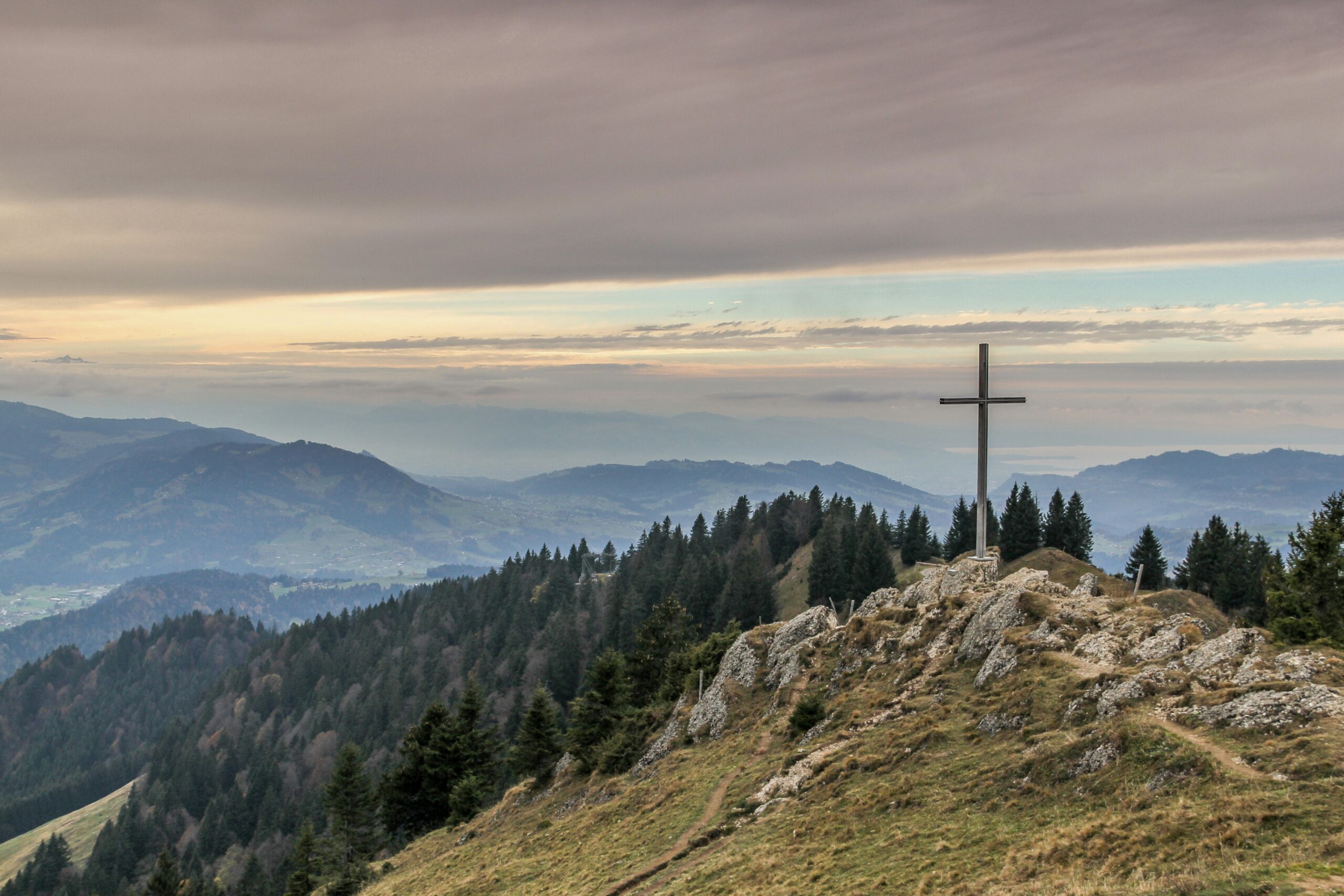 Holzkreuz mit Bergen im Hintergurnd, Foto von Thanti Riess auf Unsplash